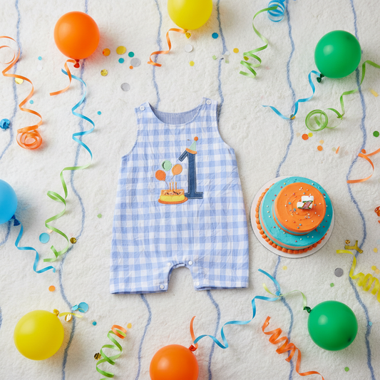 Blue gingham 1st birthday romper styled with colourful balloons and birthday cake