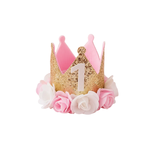First Birthday Crown Hat styled with rose petals and gold confetti on pastel pink background