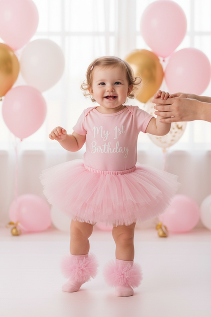 Baby girl standing showing off pink frilly tutu socks with pink birthday tutu outfit